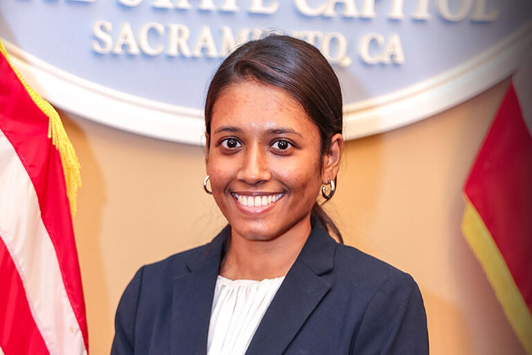 Headshot of PS Nandini in front of the California State Capital sign